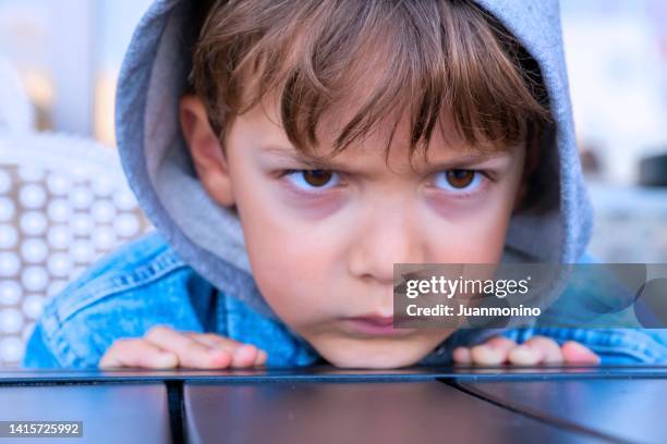 sehr enttäuschter kleiner junge mit kapuze - trotzanfall stock-fotos und bilder