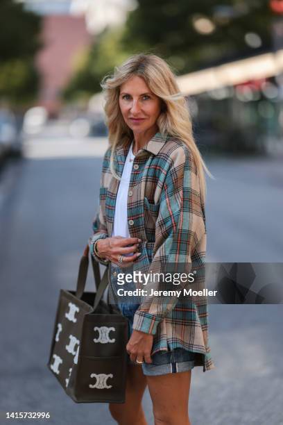 Sue Giers is seen wearing Celine brown beige and white big bag and brown cowboy boots and blue Celine jeans shorts, SoSue green, blue and orange...