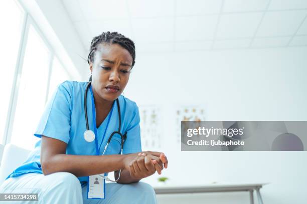 young medical practitioner looking stressed out in a hospital - tired healthcare worker stock pictures, royalty-free photos & images