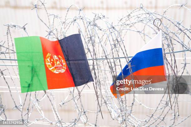 afganistán flag and russian on barbed wire. - afganistán stock-fotos und bilder