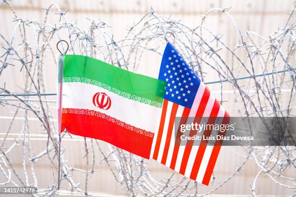iranian flag and usa ( american flag) on barbed wire. - iran fotografías e imágenes de stock