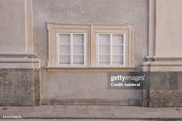 old residential building with two small windows, imperial style architecture in salzburg - traditionally austrian 個照片及圖片檔