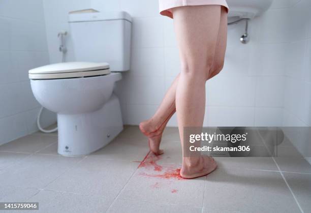 back angle female young adult standing in bathroom and free bleeding menstruation at home - period blood foto e immagini stock