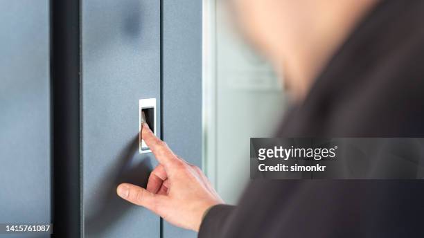 man's finger pressing on fingerprint scanner to enter his house - fingerprint scanner stock pictures, royalty-free photos & images