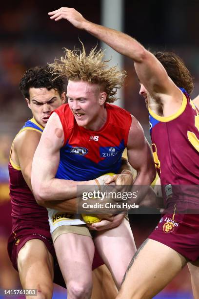 Clayton Oliver of the Demons is tackleduring the round 23 AFL match between the Brisbane Lions and the Melbourne Demons at The Gabba on August 19,...