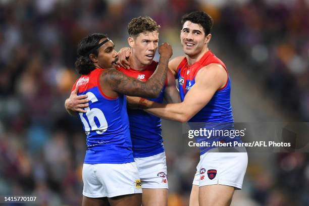 Christian Petracca of the Demons celebrates with Kysaiah Pickett and Jake Melksham after kicking a goal during the round 23 AFL match between the...