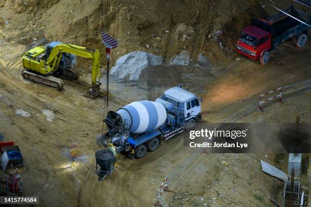 concrete cement truck working at night - betonmischmaschine stock-fotos und bilder