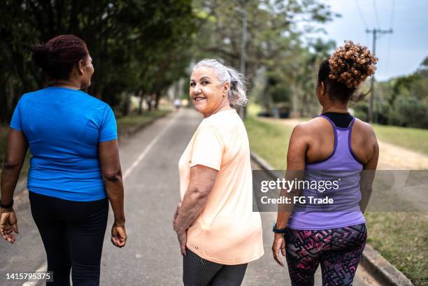 portrait of a senior woman walking in the park with friends - woman normal old diverse stock pictures, royalty-free photos & images