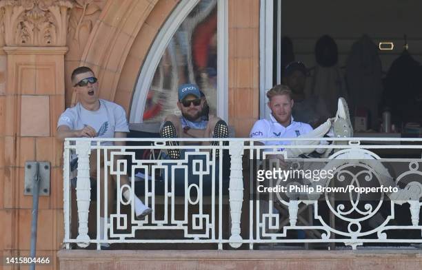 Zak Crawley, Brendon McCullum and Ben Stokes of England look on from the dressing room balcony during the third day of the first Test between England...