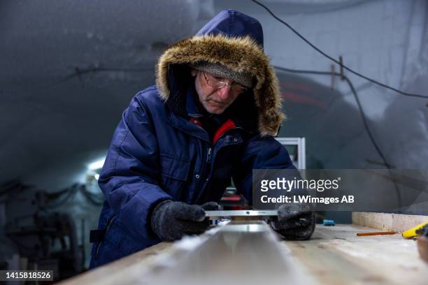 Sepp Kipfstuhl of the East Greenland Ice-Core Project carefully cleans the plane surface of the ice core slab, which later will be cut into pieces 2,...
