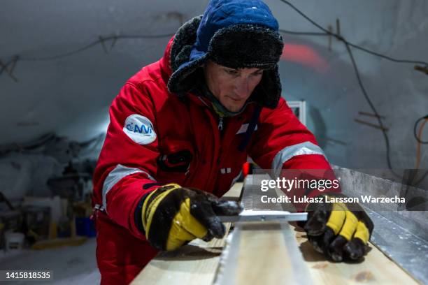 Nico Stoll of the East Greenland Ice-Core Project carefully cleans the plane surface of the ice core slab, which later will be cut into pieces 2, 3...