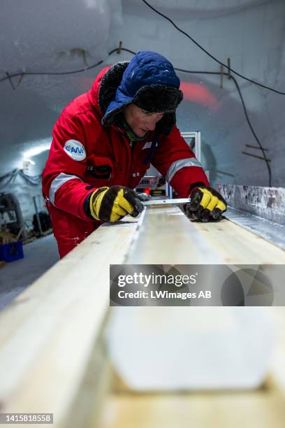 Nico Stoll of the East Greenland Ice-Core Project carefully cleans the plane surface of the ice core slab, which later will be cut into pieces 2, 3...