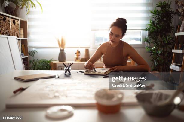 young woman drawing with charcoal in her studio - carbon paper stockfoto's en -beelden