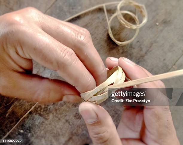 the activity of both hands making handicrafts from bamboo - making a basket imagens e fotografias de stock