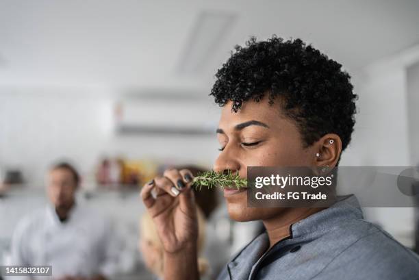 woman smelling fresh herbs in a cooking class - country origin training session stock pictures, royalty-free photos & images