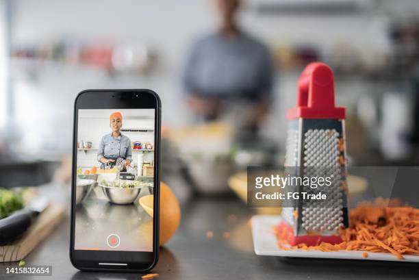 chef che filma il corso di cucina sullo smartphone - cooking event foto e immagini stock