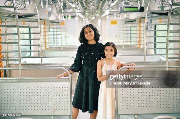 two girls standing in a train - mumbai train stock pictures, royalty-free photos & images