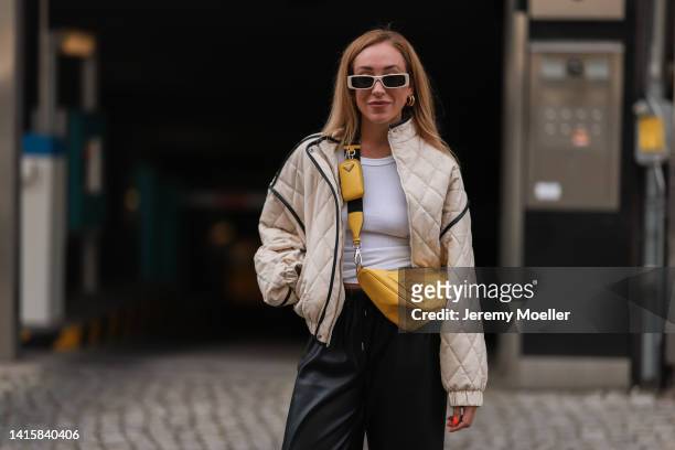 Sonia Lyson wearing Prada yellow triangle leather bag, The Frankie Shop vegan leather pants, Weekday white top, Essential Antwerp vegan leather beige...