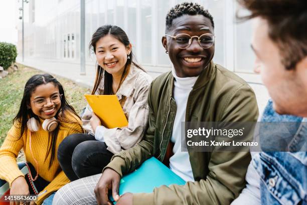 multiethnic group of young student friends hanging out at university campus - asian teenage girl is smiling at camera - international erasmus exchange concept - international student day stock-fotos und bilder