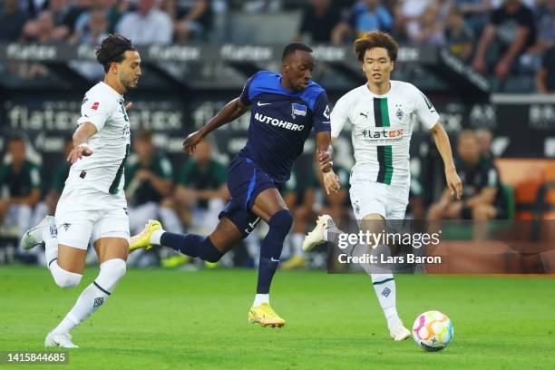 Dodi Lukebakio of Hertha is challenged by Ramy Bensebaini and Ko Itakura of Moenchengladbach during the Bundesliga match between Borussia...