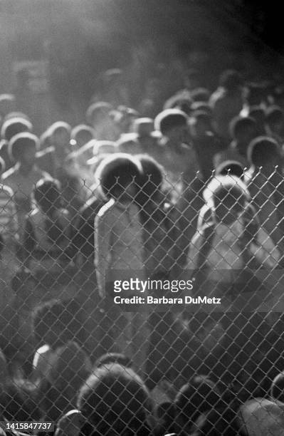 View, though a fence, of concert goers as they attend an event as part of the Watts Summer Festival at Will Rogers Memorial Park , Los Angeles,...