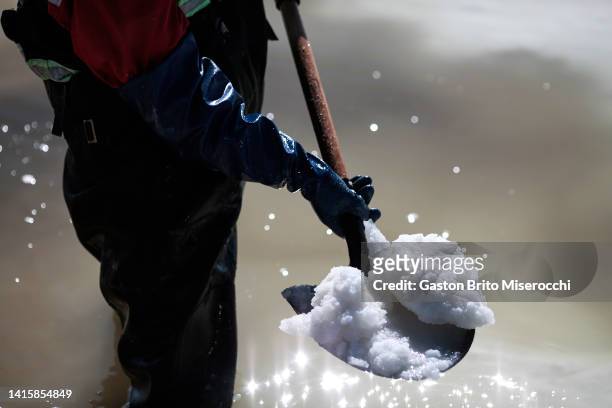 Worker uses a shovel to move the raw material for the manufacture of lithium carbonate inside a salt recovery pool at the Llipi pilot Plant in the...