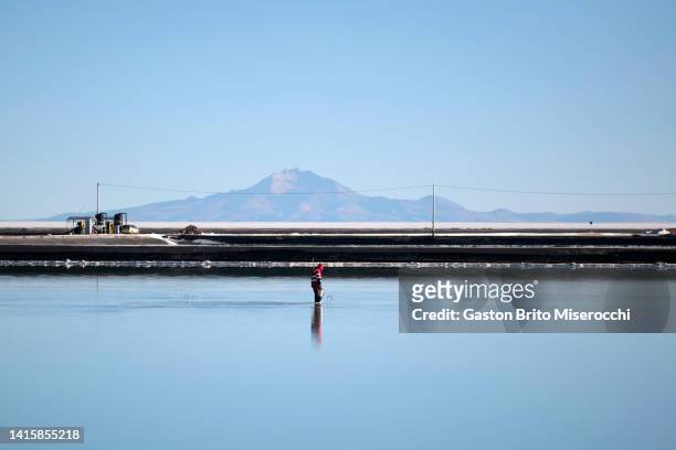 Worker takes samples from a salt recovery pool at the Llipi pilot Plant in the Uyuni Salt Flats on August 14, 2022 in Uyuni, Bolivia. The Uyuni Salt...