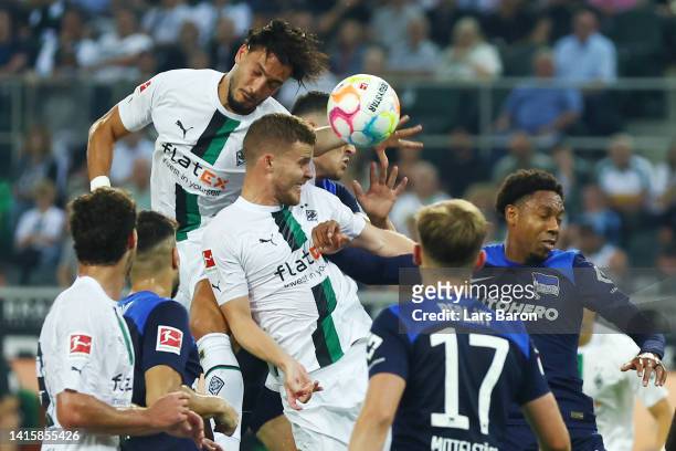 Filip Uremovic of Hertha touches the ball with the arm for a penalty whilst jumping for a header with Ramy Bensebaini and Nico Elvedi of...