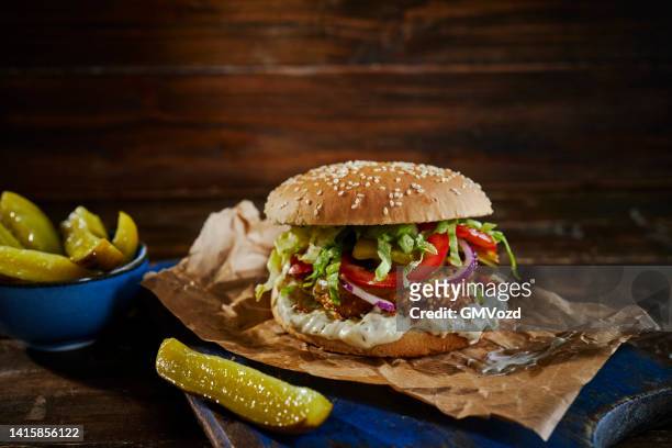 クリスピーチキンバーガー、チーズ、トマト、タマネギ、グリーンサラダ - 鶏胸肉のグリル ストックフォトと画像