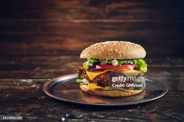 crispy chicken burger with cheese, tomato, onions and green salad - fried chicken burger stock pictures, royalty-free photos & images