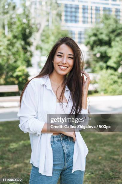 portrait of young asian woman student with long hair in city park - hair editorial stock pictures, royalty-free photos & images