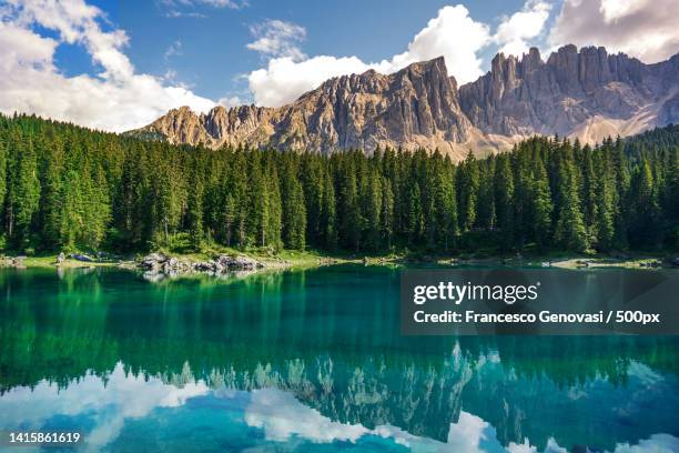 panoramic view of lake and mountains against sky,lago di carezza,nova levante,bolzano,italy - bolzano stock pictures, royalty-free photos & images