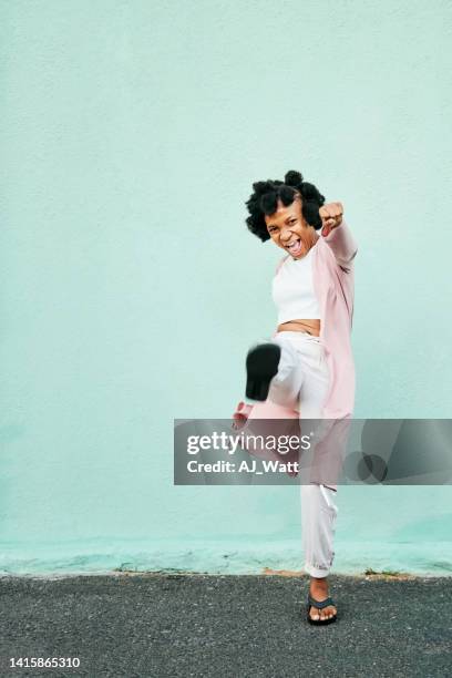 興奮したアフリカの女性が空気を蹴ってパンチする - 空手　蹴る　not子供 ストックフォトと画像