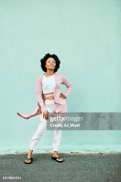 beautiful african woman in stylish outfit against turquoise wall - mint green stock pictures, royalty-free photos & images