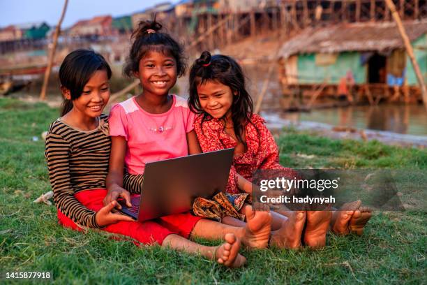 happy cambodian girls using laptop in village, cambodia - teen girl barefoot at home stock pictures, royalty-free photos & images