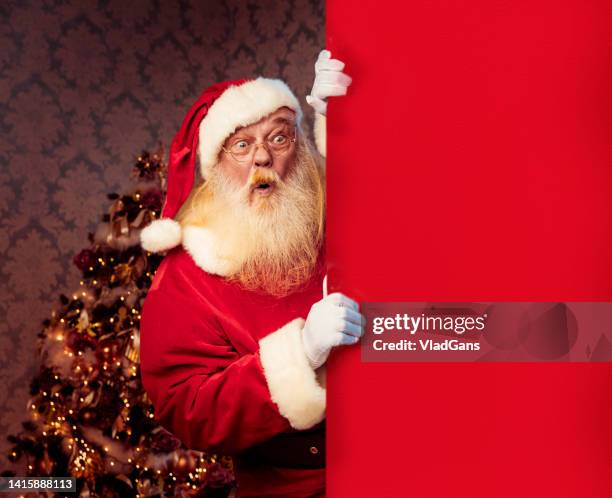 weihnachtsmann zeigt auf leere banner - father christmas stock-fotos und bilder