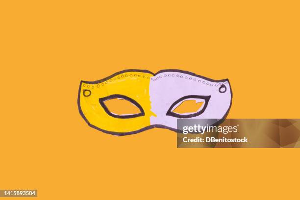 yellow and white cardboard mask, painted and cut out by a child, to celebrate carnival, with hard shadow, on yellow background. carnival and masquerade celebration concept. - gala stock pictures, royalty-free photos & images