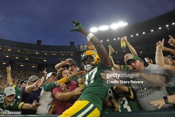 Romeo Doubs of the Green Bay Packers leaps into the stands following a touchdown reception against the New Orleans Saints during the first half of a...