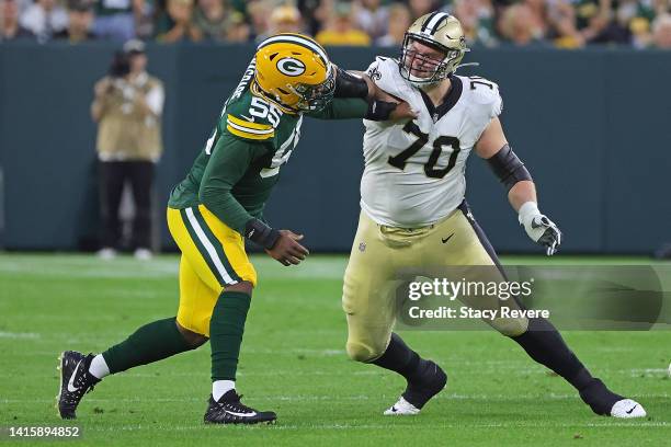 Trevor Penning of the New Orleans Saints works against Kingsley Enagbare of the Green Bay Packers during the first half of a preseason game at...