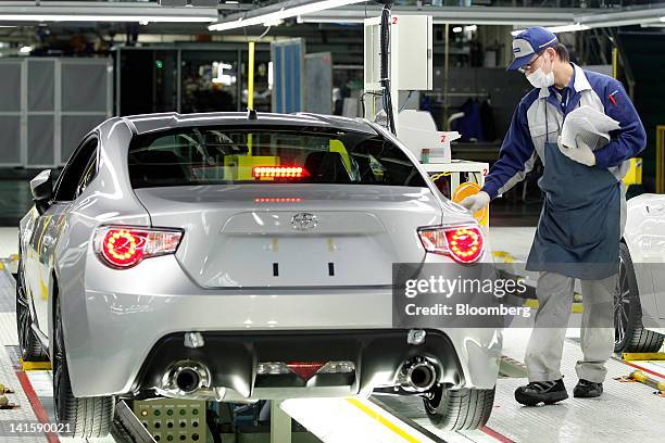 Fuji Heavy Industries Ltd. Employee inspects a Toyota Motor Corp. 86 sports coupe on the Subaru BRZ and Toyota 86 production line at Fuji Heavy's...