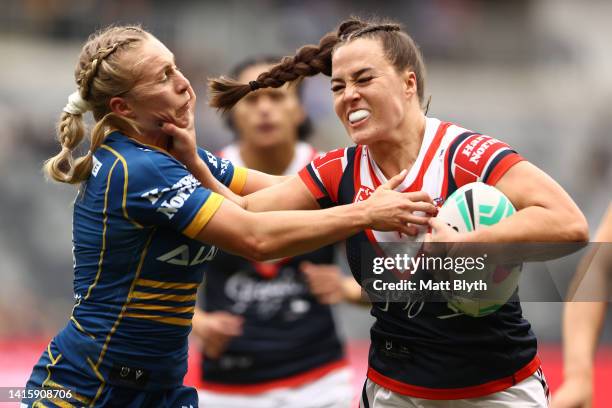 Isabelle Kelly of the Roosters fends Abbi Church of the Eels during the round one NRLW match between the Parramatta Eels and the Sydney Roosters at...