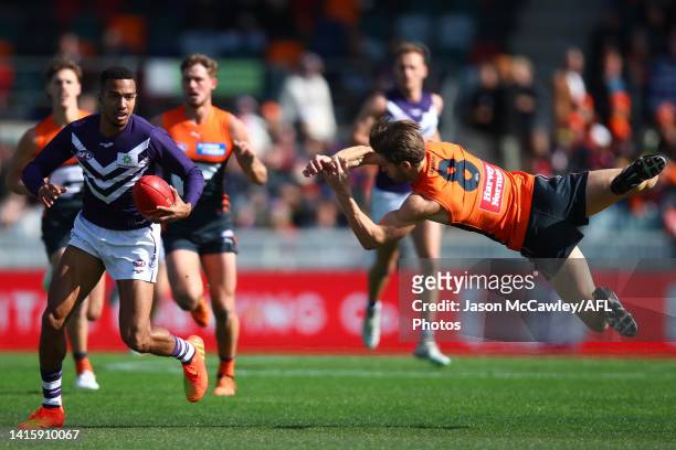Brandon Walker of the Dockers evades the tackle by Callan Ward of the Giants during the round 23 AFL match between the Greater Western Sydney Giants...