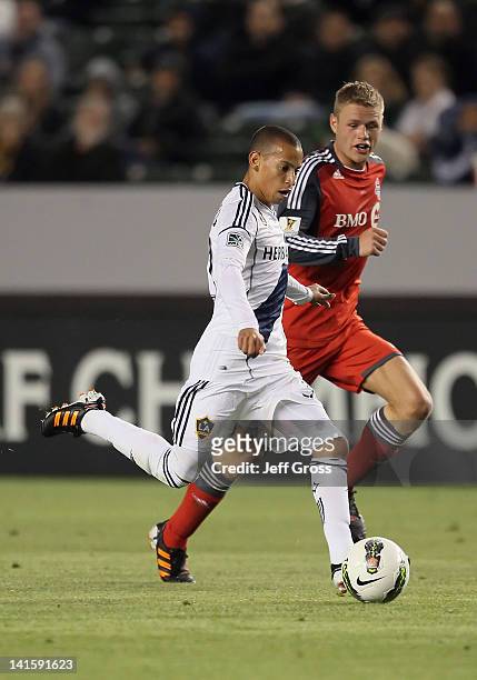 Paolo Cardozo of the Los Angeles Galaxy is pursued by Nick Soolsma of Toronto FC during a CONCACAF Champions League game at The Home Depot Center on...