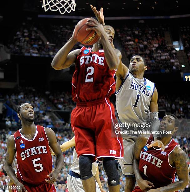 Wolfpack's guard Lorenzo Brown , center, gathers in a very late 2nd half rebound over Hoyas forward Hollis' Thompson as NorthCarolina State Wolfpack...