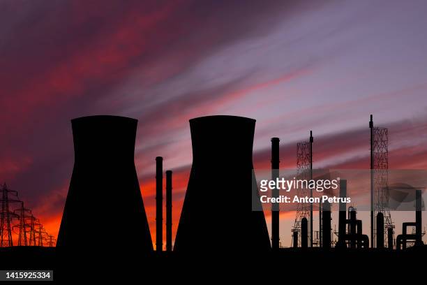 nuclear power plant at sunset - atomic imagery stock-fotos und bilder