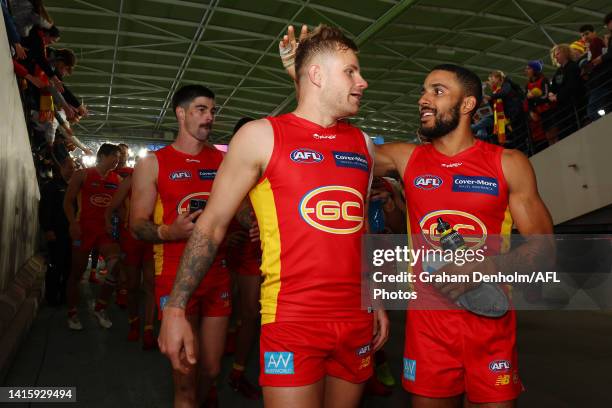 Touk Miller of the Suns and teammate Brandon Ellis embrace following victory in the round 23 AFL match between the North Melbourne Kangaroos and the...