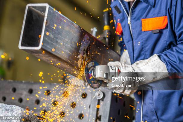 worker using angle grinder for cleaning metal material surface - slijptol stockfoto's en -beelden