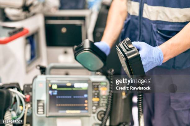 paramedic using a defibrillator - desfibrilador fotografías e imágenes de stock