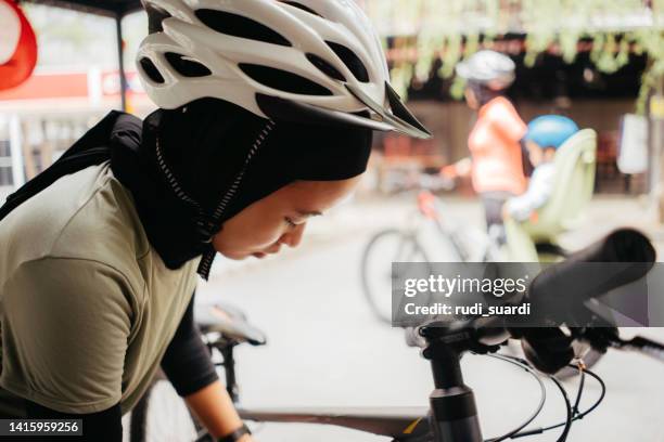 muslimische frau, die mit dem fahrradsport beginnt - baby sturzhelm stock-fotos und bilder