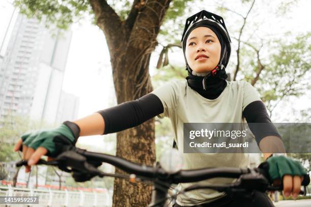 young muslim woman with bicycle  on the city park - islamic action front stock pictures, royalty-free photos & images